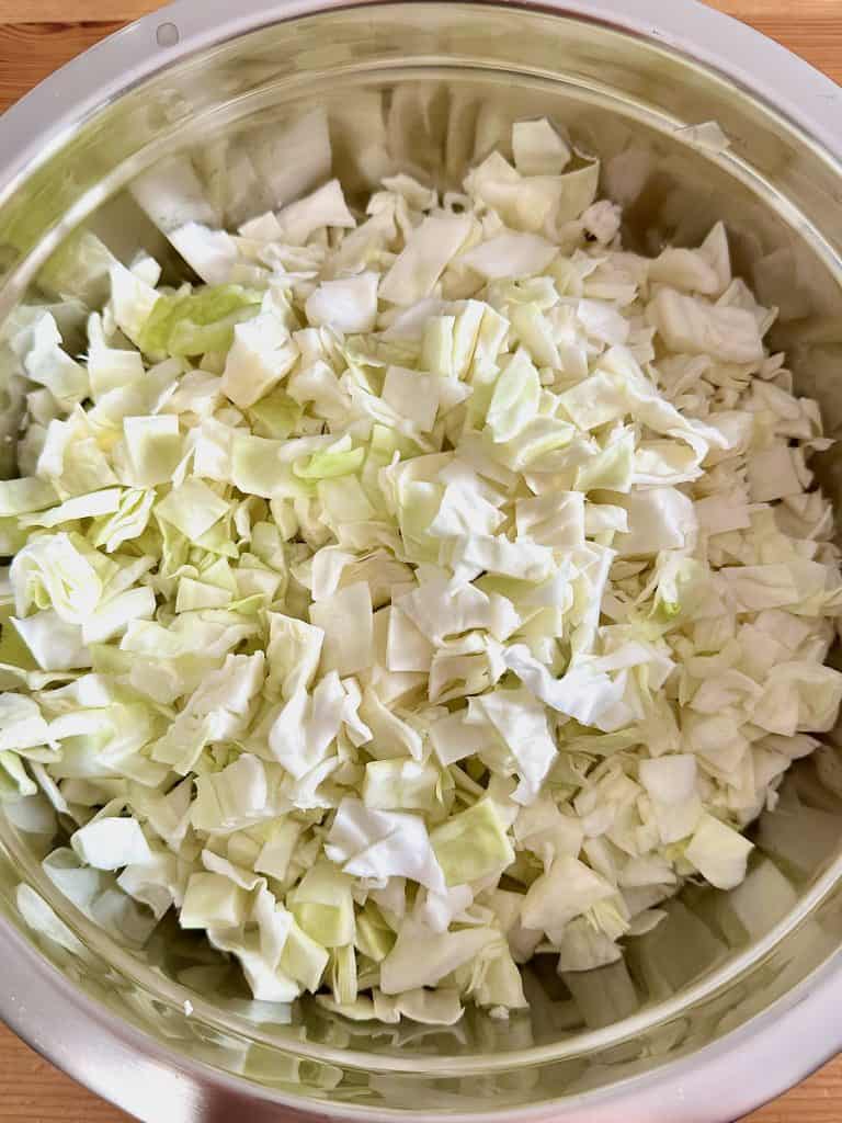 Chopped, raw, green cabbage in a silver metal bowl
