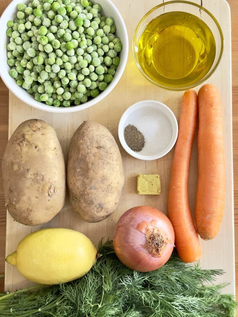 Ingredients to make Instant Pot Greek Artichoke Stew recipe on a wooden cutting board