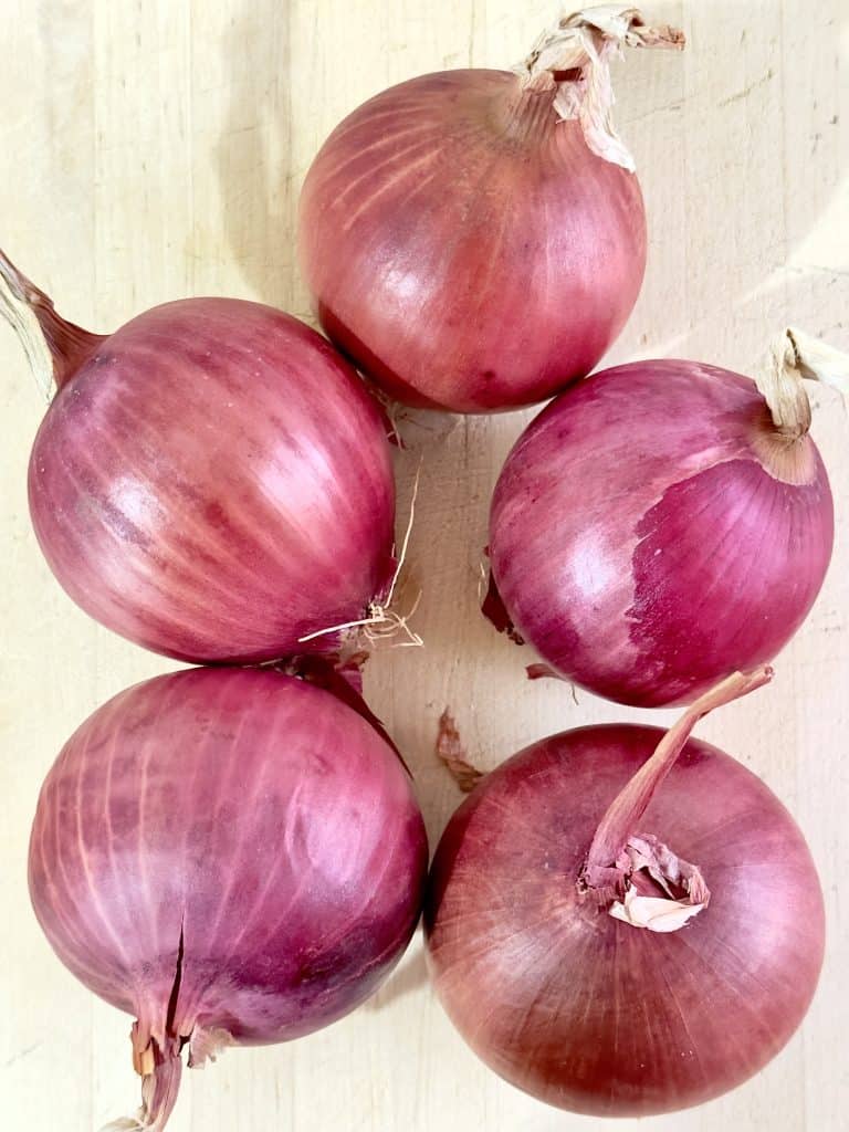 Red onions on a wooden cutting board