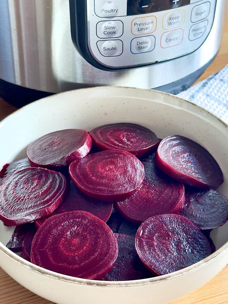 Cooked, sliced beets next to an Instant Pot