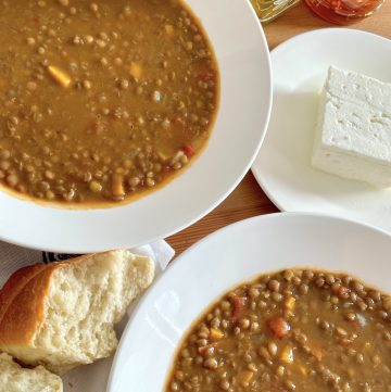 Mediterranean diet meal - Two bowls of Greek lentil soup served with a piece of bread and a slice of feta