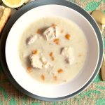 Instant Pot Greek Avgolemono Soup recipe in a bowl with lemon and bread on the side